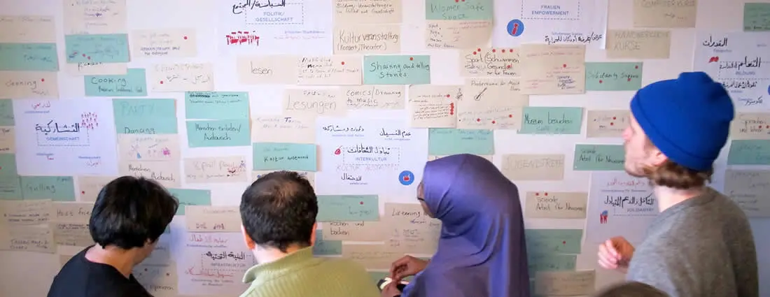 People standing in front of a pinboard